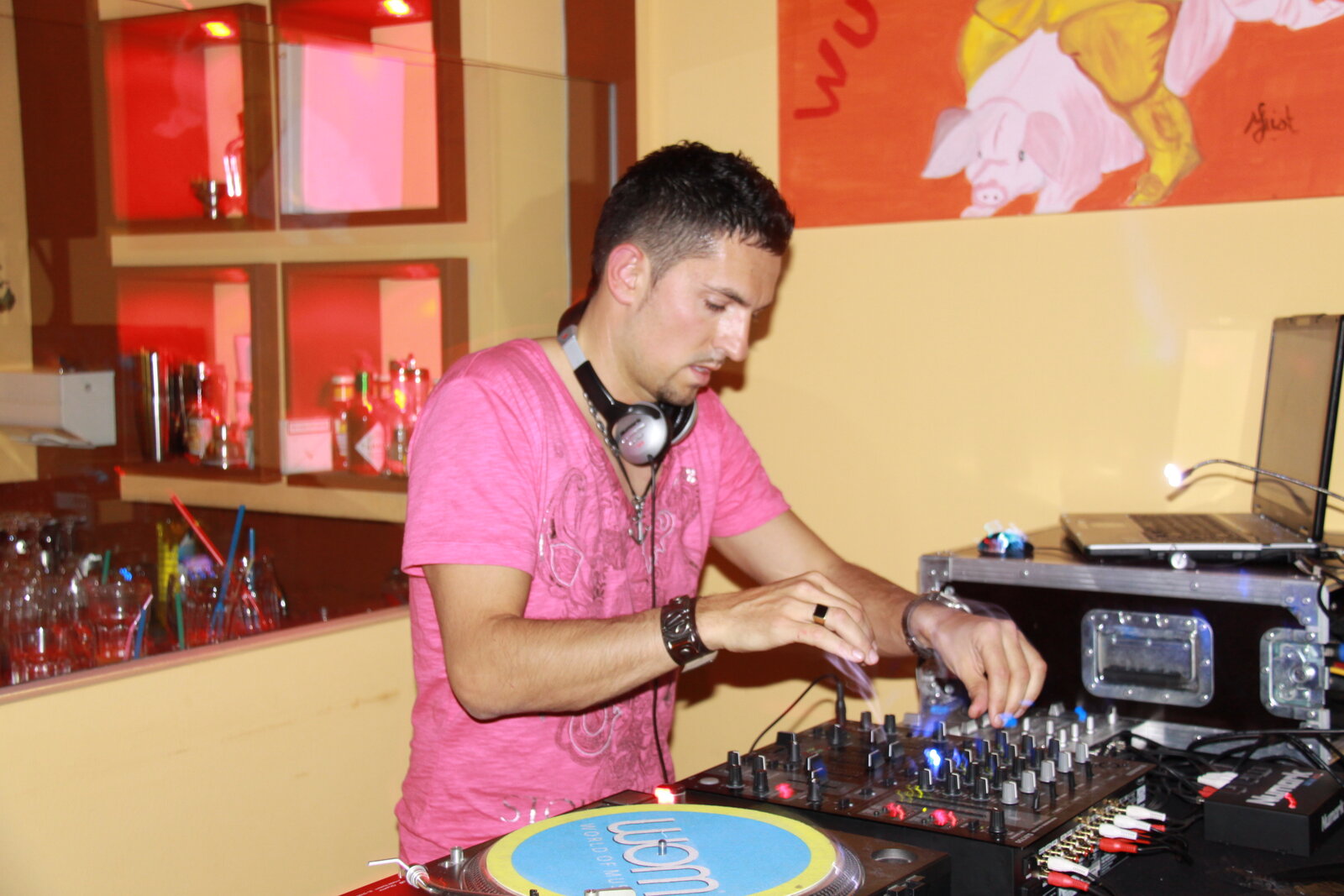 DJ Saint-Tropez en t-shirt rose mixant sur platines vinyle en lounge